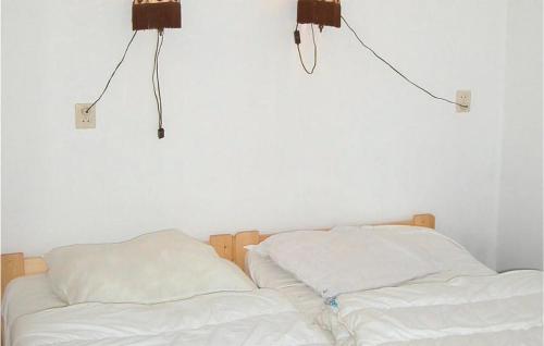 twee bedden met witte lakens en twee lampen aan de muur bij Awesome Apartment In Saaxumhuizen With 1 Bedrooms And Wifi in Saaxumhuizen