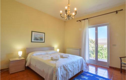 una camera con letto, finestra e lampadario a braccio di Casa Vacanza Biaure a Santo Stefano di Camastra