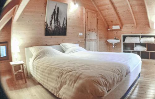 een slaapkamer met een groot bed in een houten kamer bij Boshuisje Veluwe Goudplevier in Emst