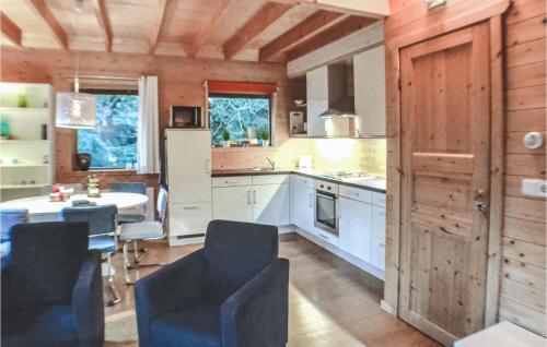 a kitchen with white cabinets and a table with chairs at Boshuisje Veluwe Goudplevier in Emst