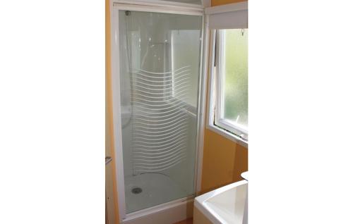 La salle de bains est pourvue d'une douche avec une porte en verre. dans l'établissement Gorgeous Home In Tzummarum With Kitchen, à Tzummarum