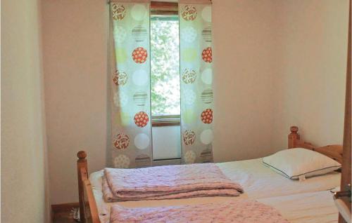 a bedroom with a bed and a window with curtains at 2 Bedroom Awesome Home In Mönsterås in Mönsterås
