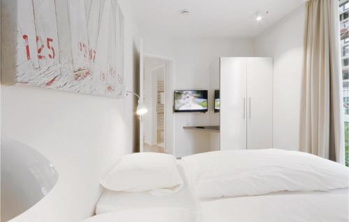 a white bedroom with a bed and a mirror at Promenadenvilla in Priwall