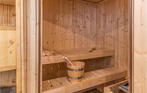 a wooden sauna with a bucket in it at 3 Bedroom Cozy Home In Friedrichskoog in Friedrichskoog