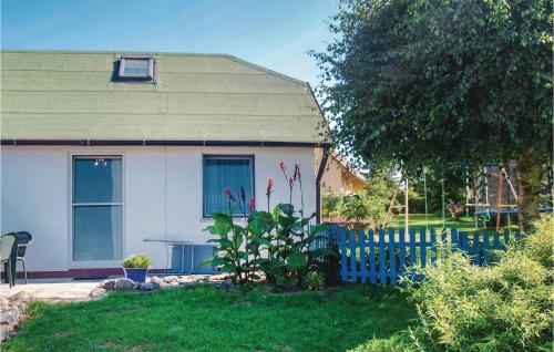 una piccola casa con una recinzione blu in un cortile di Nice Home In Usedom With Kitchen a Wilhelmshof