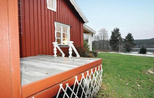 a porch of a red house with a bench on it at Cozy Home In Östra Ämtevik With Sauna in Östra Ämtervik