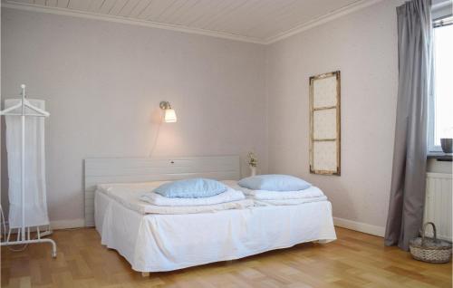 Södra ViにあるGorgeous Apartment In Sdra Vi With Kitchenの白いベッドルーム(青い枕の白いベッド付)