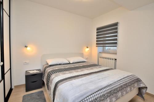 Un dormitorio con una cama grande y una ventana en Apartment Opatija hills, en Matulji