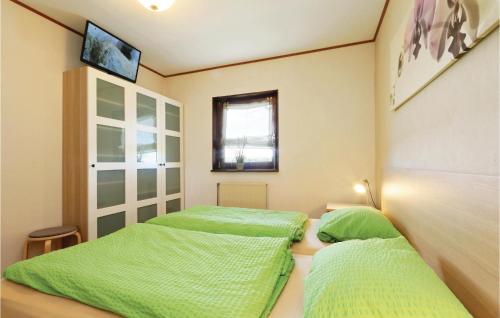 two beds in a room with green sheets at Ferienhaus 10 In Thalfang in Thalfang