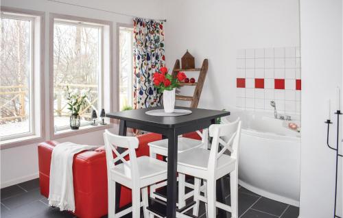 ビンメルビューにあるAwesome Home In Vimmerby With Wifiのバスルーム(テーブル、椅子2脚、バスタブ付)