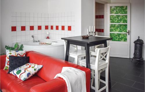 1 Bedroom Awesome Home In Vimmerby في فيمربي: غرفة معيشة مع أريكة حمراء وطاولة