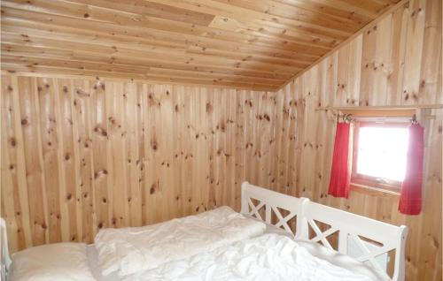 ein Schlafzimmer mit einem Bett in einer Holzwand in der Unterkunft Cozy Home In Ringebu With Kitchen in Ringebu
