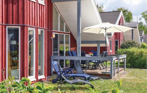 a table and chairs and an umbrella next to a house at 3 Bedroom Gorgeous Home In Rechlin in Rechlin