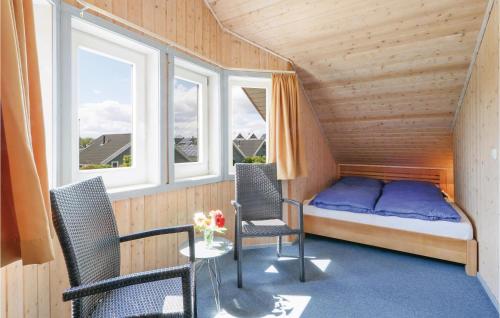レヒリンにあるAmazing Home In Rechlin With 3 Bedrooms And Wifiのベッド1台、椅子2脚、テーブルが備わる小さな客室です。