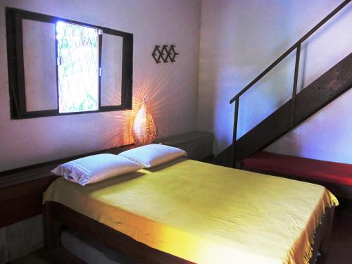a bedroom with a bed with a window and a staircase at Stay Cool Pipa in Pipa