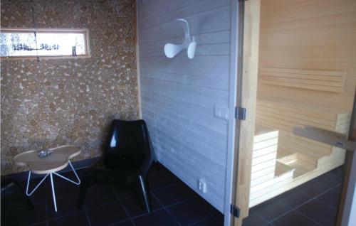 a bathroom with a black chair and a tub at Stunning Home In Vaggeryd With Sauna in Vaggeryd