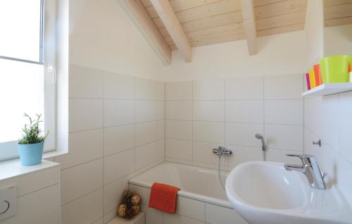 Baño blanco con lavabo y bañera en Seeteufel 6, en Süssau