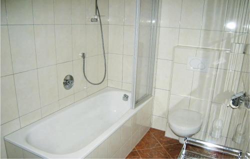 a bathroom with a tub and a toilet and a shower at Beautiful Apartment In St, Anton With 2 Bedrooms, Internet And Sauna in Sankt Anton am Arlberg