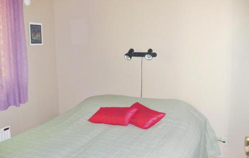 - une chambre avec un lit et un oreiller rouge dans l'établissement Cozy Home In Nossebro With Kitchen, à Lekåsa