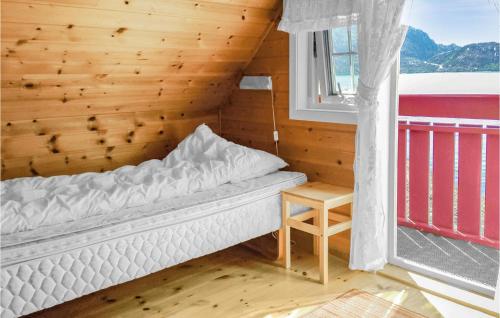 a bed in a room with a wooden wall at 2 Bedroom Lovely Home In Hyllestad in Hovland