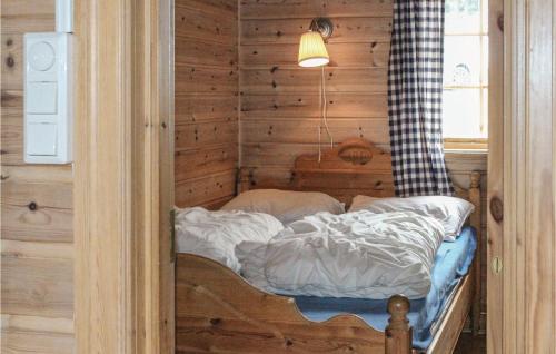 Ce petit lit se trouve dans une chambre dotée d'un mur en bois. dans l'établissement Beautiful Home In Vik I Sogn With 2 Bedrooms And Wifi, à Espeset