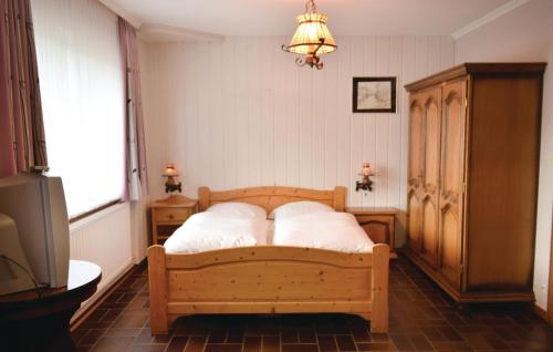a bedroom with a wooden bed with two pillows at Stunning Apartment In Bllingen With Kitchen in Bullange