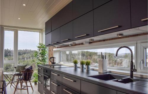 a kitchen with black cabinets and a large window at Beautiful Home In Søndeled in Søndeled