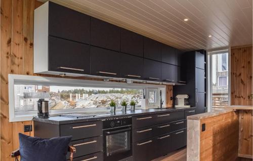 a kitchen with black cabinets and a window at Beautiful Home In Søndeled in Søndeled