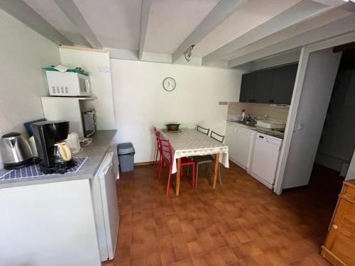 une petite cuisine avec une table et une table et des chaises dans l'établissement Charmante maisonnette proche centre et plage, terrasse, parking et à 1km des plages ! - FR-1-550-41, aux Mathes