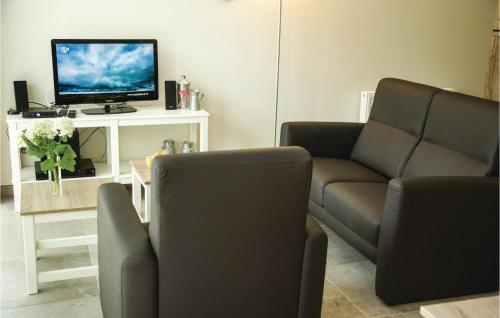 a living room with a couch and a tv at 1 Bedroom Lovely Home In Retranchement in Retranchement