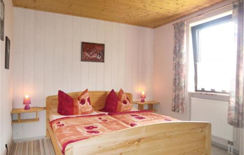 a bedroom with a bed with red pillows and a window at Stunning Apartment In Duppach With Kitchen in Duppach