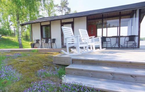 a house with white chairs and a table on a deck at Beautiful Home In Strängnäs With Sauna in Aspö