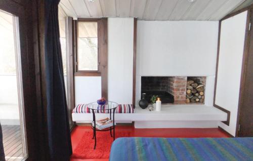 a room with a fireplace and a table and a chair at Beautiful Home In Strängnäs With Sauna in Aspö