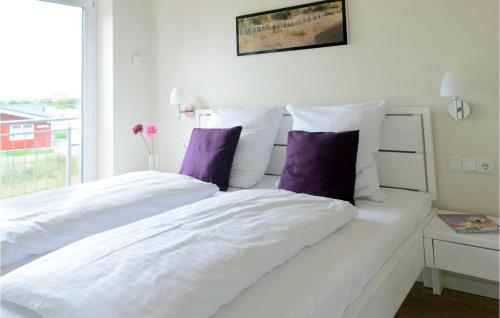 ダゲビュルにあるLovely Home In Dagebll With Saunaの白いベッド(紫色の枕付)が備わるベッドルームです。