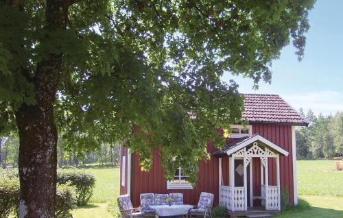 a red shed with a table and chairs next to a tree at Holiday Home Almensryd Öreryd Hestra in Hestra