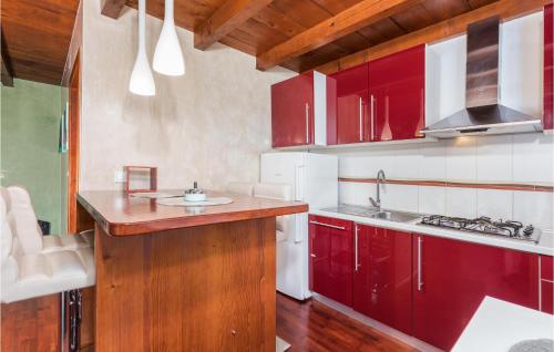 a kitchen with red cabinets and a sink at 2 Bedroom Awesome Home In Valbandon in Štinjan