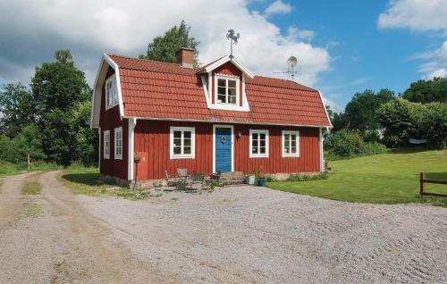 a red house with a red roof on a dirt road at Holiday Home Skogstorp Gård Holmsjö in Holmsjö
