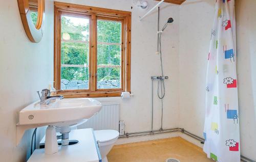 a bathroom with a sink and a toilet and a window at Holiday Home Skogstorp Gård Holmsjö in Holmsjö