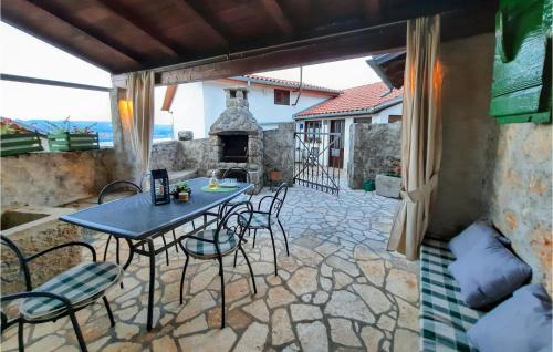 eine Terrasse mit einem Tisch, Stühlen und einem Kamin in der Unterkunft Beautiful Home In Lovran With Wifi in Lovran