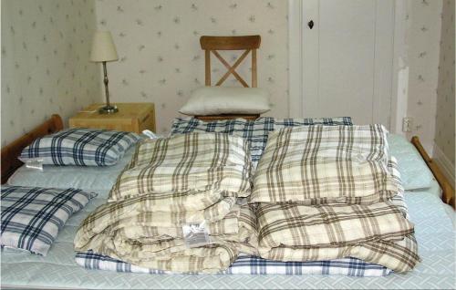 Una cama con dos mantas y una silla. en 1 Bedroom Cozy Home In Vimmerby, en Vimmerby