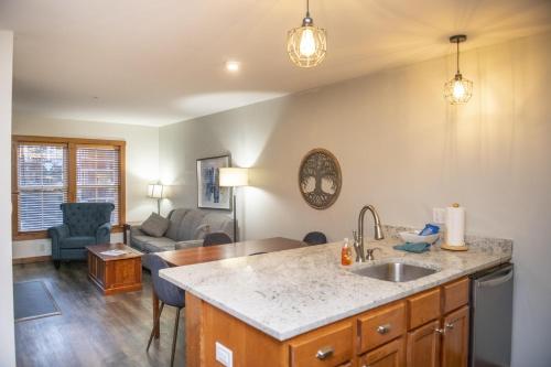 a kitchen with a sink and a living room at Allegheny Spring 239 KING, bed/Ski-In, Out/Pool & Hot Tub in Snowshoe