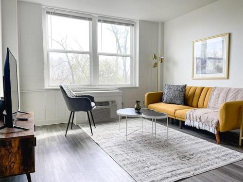 a living room with a yellow couch and a table at Sleepover Downtown Cincinnati 1BD 1BA Apartments in Cincinnati