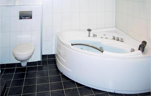 ein weißes Bad mit einer Badewanne und einem WC in der Unterkunft Nice Home In ystese With House A Mountain View in Øystese