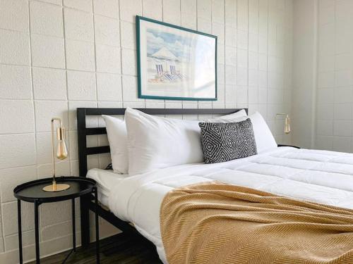 a bedroom with a large white bed and a side table at Sleepover Downtown Cincinnati 1BD 1BA Apartments in Cincinnati