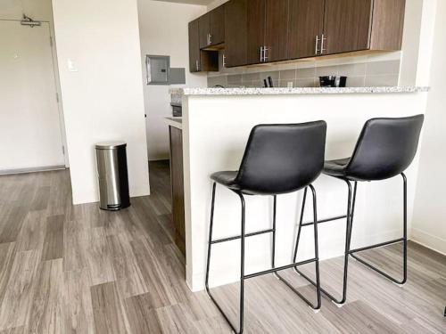 two black chairs sitting at a counter in a kitchen at Sleepover Downtown Cincinnati 1BD 1BA Apartments in Cincinnati