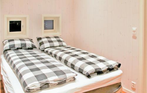two beds in a room with checkered pillows at Stunning Home In Kvisvik With 4 Bedrooms And Internet in Kvisvik