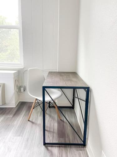 a table and a white chair in a room at Sleepover Downtown Cincinnati 1BD 1BA Apartments in Cincinnati