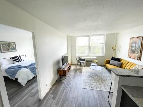 a bedroom with a bed and a living room at Sleepover Downtown Cincinnati 1BD 1BA Apartments in Cincinnati