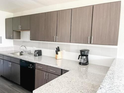 a kitchen with brown cabinets and a counter top at Sleepover Downtown Cincinnati 1BD 1BA Apartments in Cincinnati