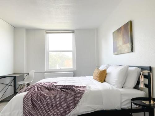 a white bedroom with a bed and a window at Sleepover Downtown Cincinnati 1BD 1BA Apartments in Cincinnati